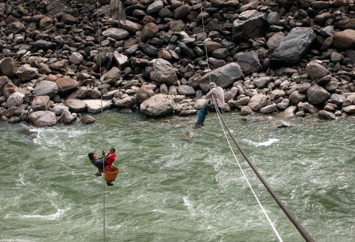 Habitantes locais usam cordas para se locomover acima de um rio na China